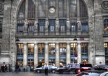 man walking crossing street in front of building