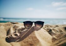 black Ray-Ban Wayfarer sunglasses on beach sand