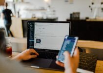 person using phone and laptop