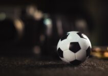 white and black soccer ball on black sand