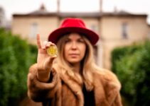 woman in brown fur coat holding yellow heart ornament