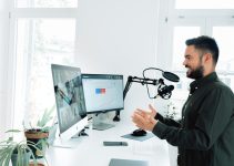 man in black jacket holding black corded computer mouse