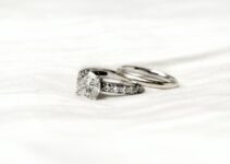 silver diamond ring on white textile