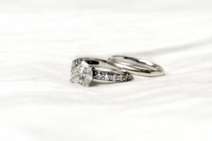 silver diamond ring on white textile