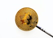 gold round coin on white surface