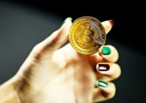 person holding gold round coin