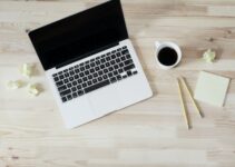 turned off MacBook Pro beside white ceramic mug filled with coffee