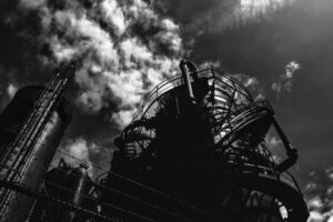 grayscale photo of ferris wheel under cloudy sky