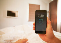 persona en la cama doble en el teléfono alarma - morning alarm fotografías e imágenes de stock