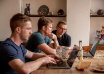 man in blue crew neck t-shirt sitting beside woman in black tank top