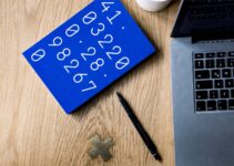 A computer and a blue notebook Description automatically generated