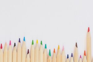 colored pencil lined up on top of white surface