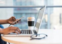 person using smartphone and MacBook