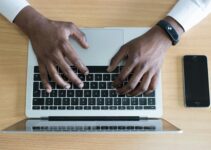Closeup Photo of Person's Hands on Macbook Beside Space Gray Iphone 5s