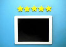 Tablet with five yellow stars on a blue background, ideal for rating concepts.