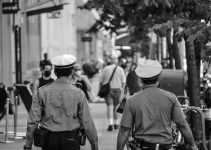 grayscale photo of man in jacket and hat