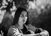 A woman sitting on a bench in a park