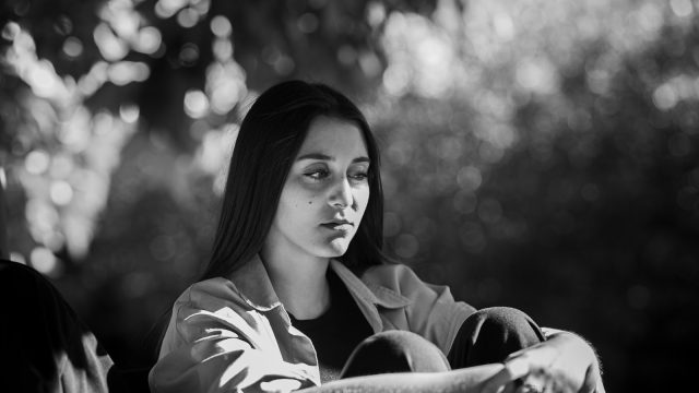 A woman sitting on a bench in a park