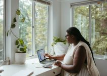 a woman sitting at a table with a laptop