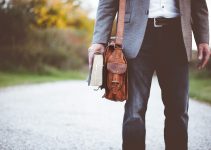 man holding book on road during daytime