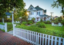 white wooden fence near white and brown house