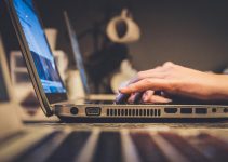 person using silver laptop computer on desk