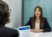a woman sitting at a table with a piece of paper in front of her