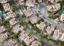Explore a stunning aerial view of a residential area in Dubai with lush greenery and swimming pools.