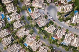 Explore a stunning aerial view of a residential area in Dubai with lush greenery and swimming pools.