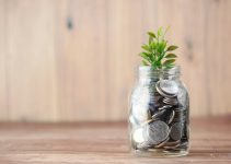 a glass jar filled with coins and a plant
