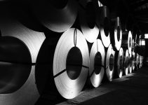 rolls of steel are lined up in a warehouse