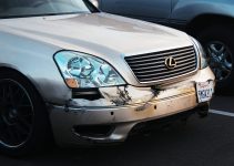 a car that has been badly damaged in a parking lot