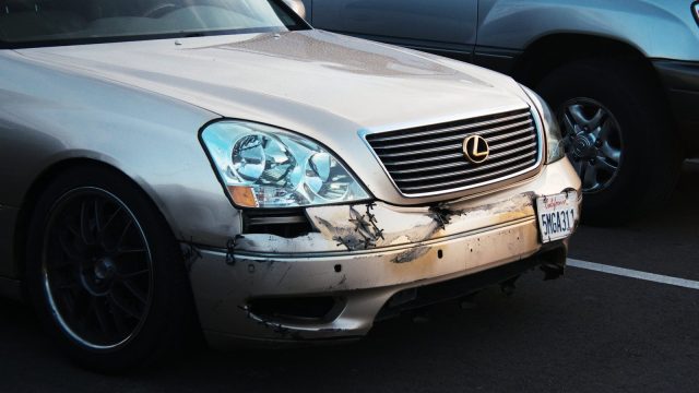 a car that has been badly damaged in a parking lot